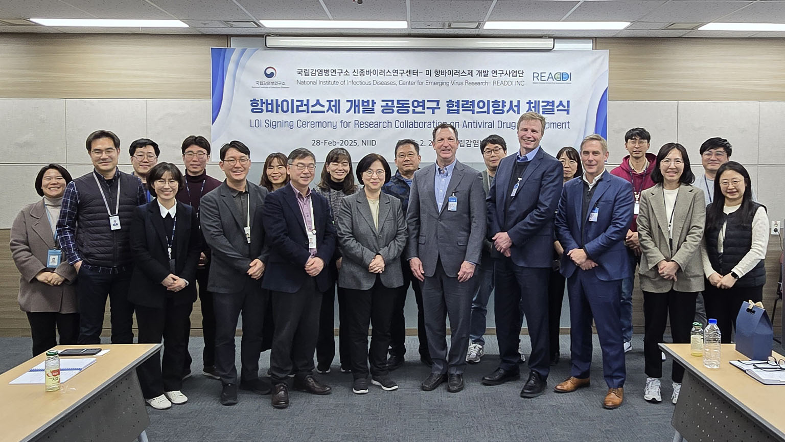 Group photo in front of banner in English and Korean